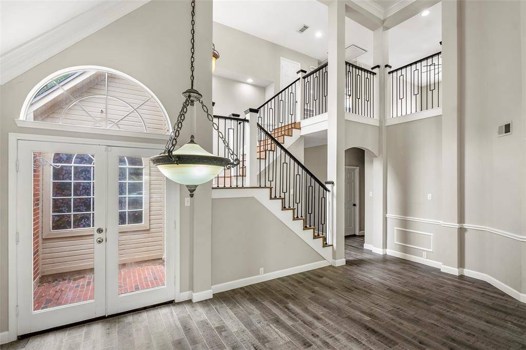 A beautiful formal dining space is anchored by a stunning chandelier and has double doors that open to the outdoor atrium area!