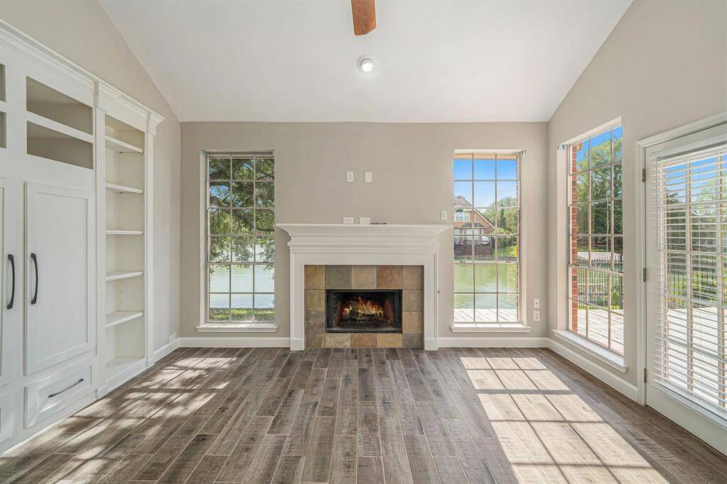A stunning family room awaits you! Custom built-ins, light and airy and offering amazing views of the neighborhood lake!