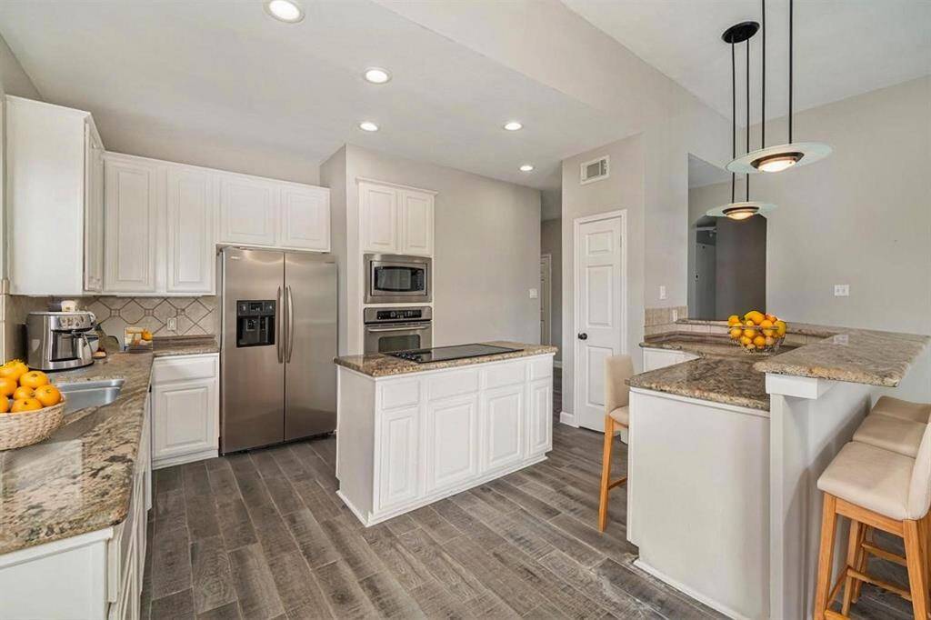 A wonderful island kitchen with crisp white cabinets offers plenty of storage space for the chef of the home!
