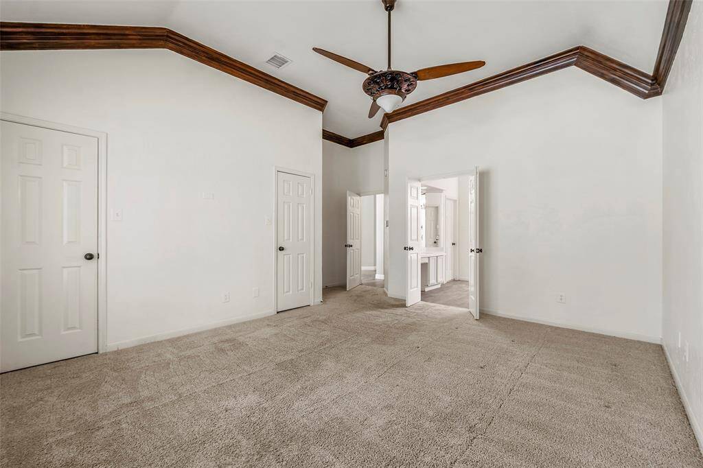 Welcome to the cozy primary suite accented with wood molding, soft carpet and double closets!