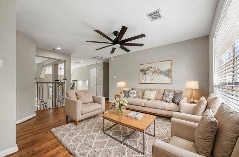 Another view of the spacious game room with laminate flooring and large ceiling fan. (virtual staging)