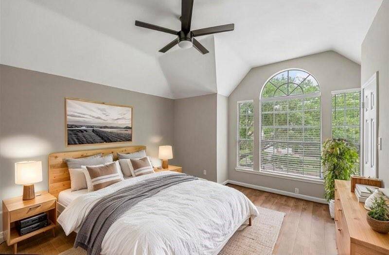 One of the two secondary bedrooms with neutral tones and views of the trees. (virtually staged)