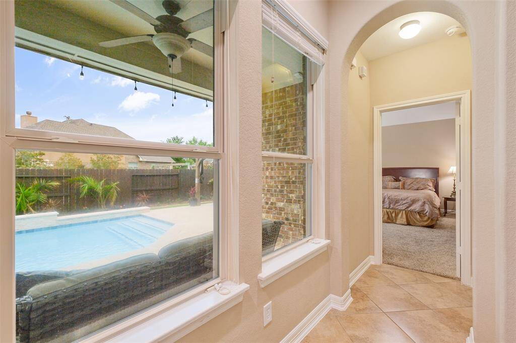 Tucked away for privacy, this serene hallway leads to the spacious primary suite—framed by a dreamy pool view that invites relaxation the moment you step in.