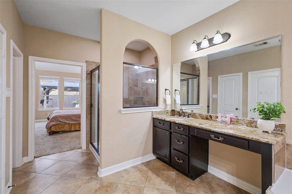 A large glass-enclosed shower and dual vanities make this ensuite both stylish and functional—featuring whole home water filtration and tankless softening for your skin and hair’s best life!