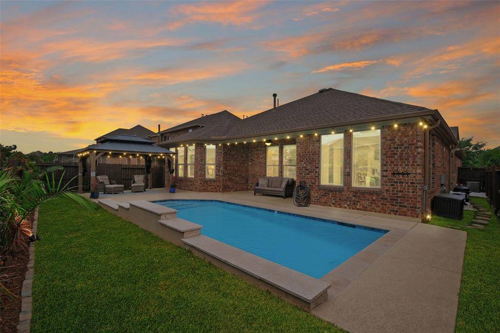 Welcome to 11614 Via Verdone Drive in Lakes of Bella Terra — where your backyard dreams come true! From sunset swims to cozy nights under twinkle lights, this sparkling pool and covered patio are ready to host all your best memories.