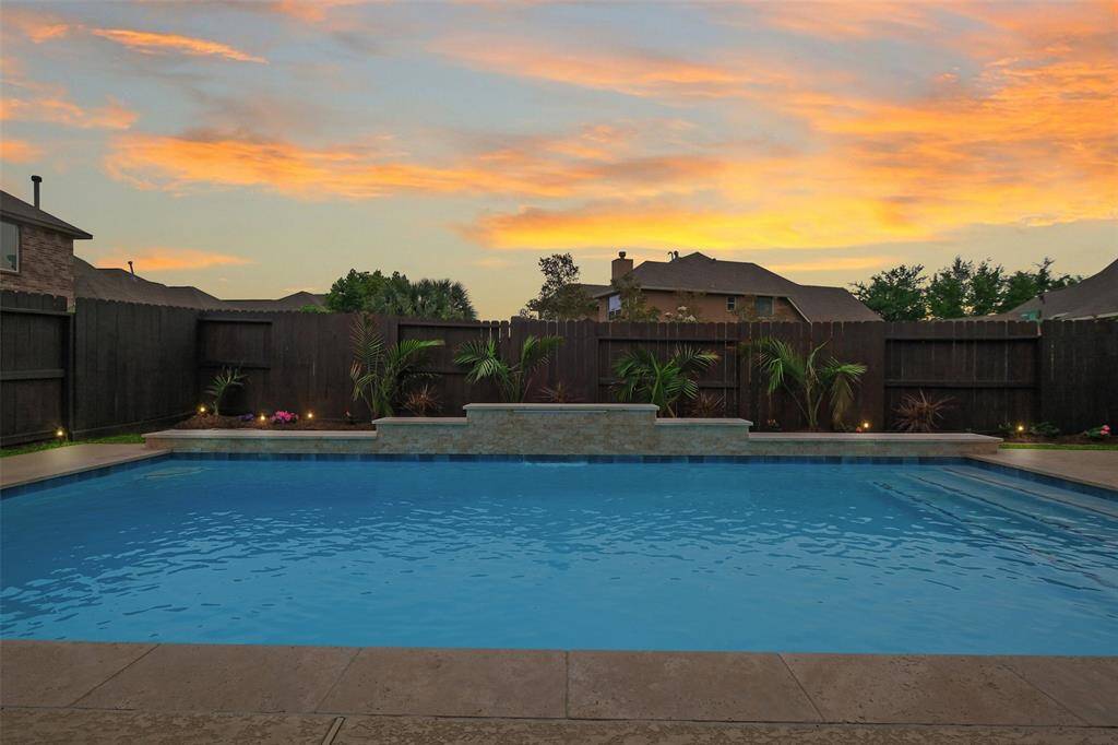 Pool goals, unlocked. With glowing landscaping, a sunset backdrop, and your own private waterfall, this backyard basically demands you cancel your weekend plans. Who needs a resort when your pool looks this dreamy?
