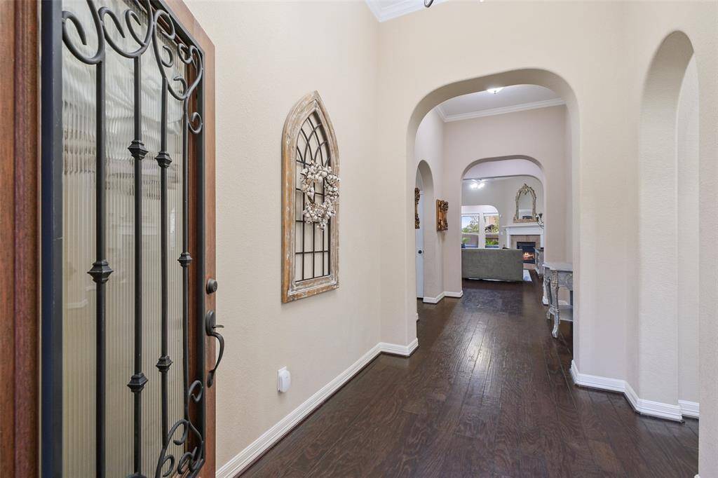 Welcome home! This grand entryway sets the tone with rich wood floors, elegant arches, and tall ceilings. Stylish Moen bronze fixtures and PEX plumbing with a central manifold hub make this home as functional as it is beautiful.