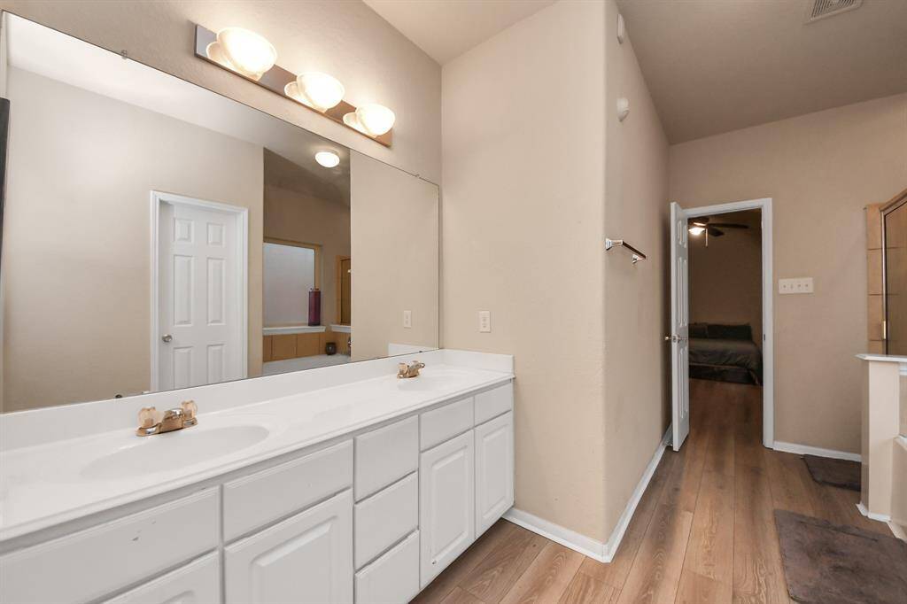 The en-suite bathroom is a true luxury, complete with a soaking tub, a separate shower, and dual vanities, providing both comfort and convenience.