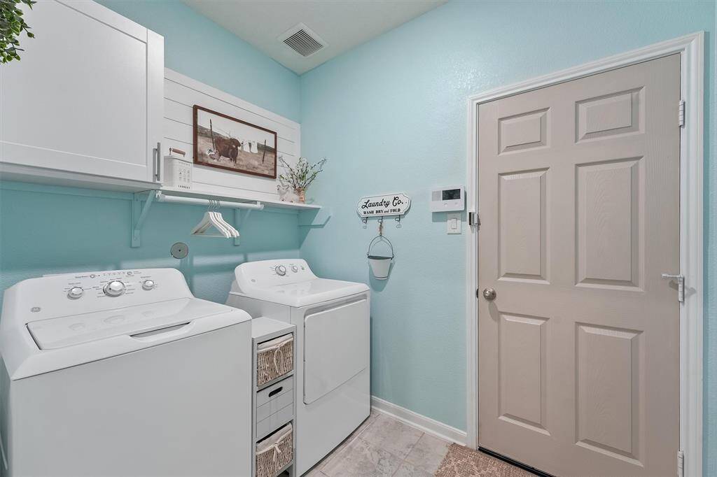 Laundry room conveniently located inside the home, offering built-in shelving and space for a full -size washer and dryer.