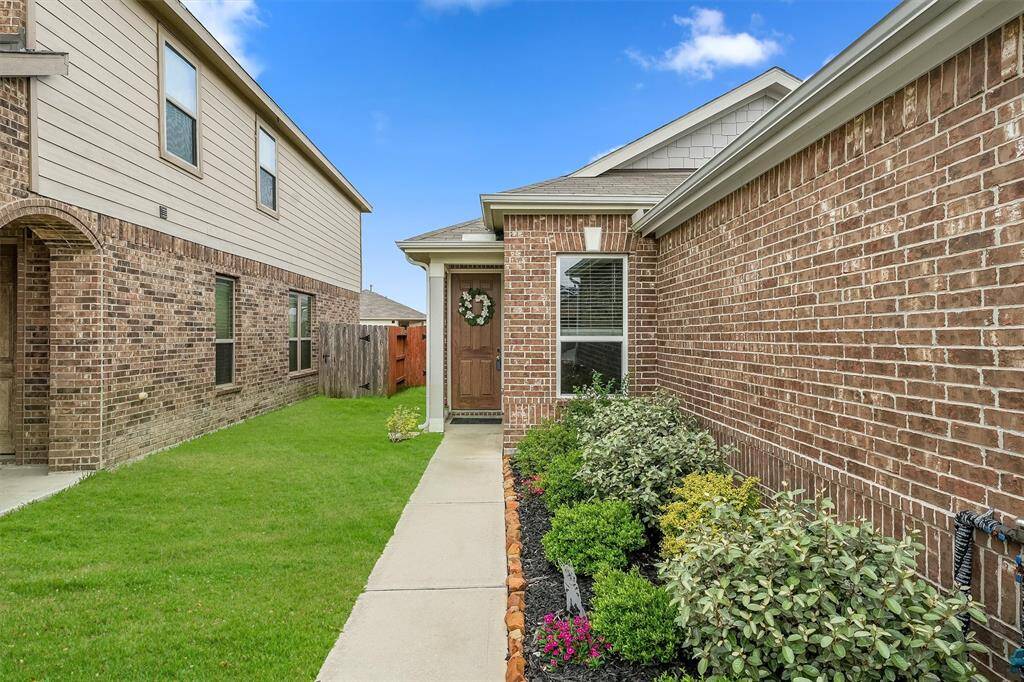Charming brick facade with manicured landscaping offers inviting curb appeal.