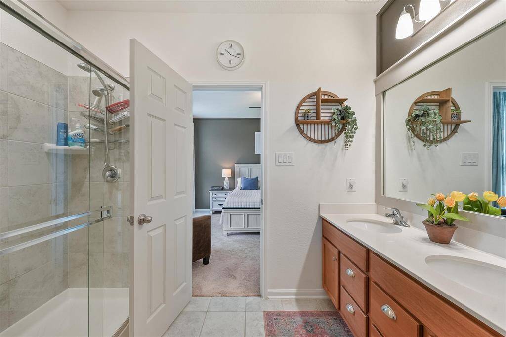 Main bathroom features a classic style with a walk-in shower enclosed by a sliding class door.