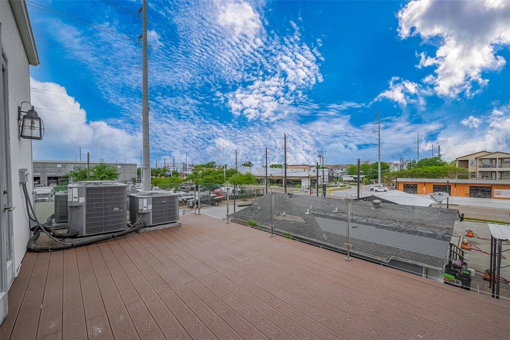 The balcony off the owner's suite features a sleek glass railing, offering transparency and modern lines without compromising safety. Enjoy a great view of the local restaurants and shops, perfect for people-watching or unwinding with a glass of wine after a long day.