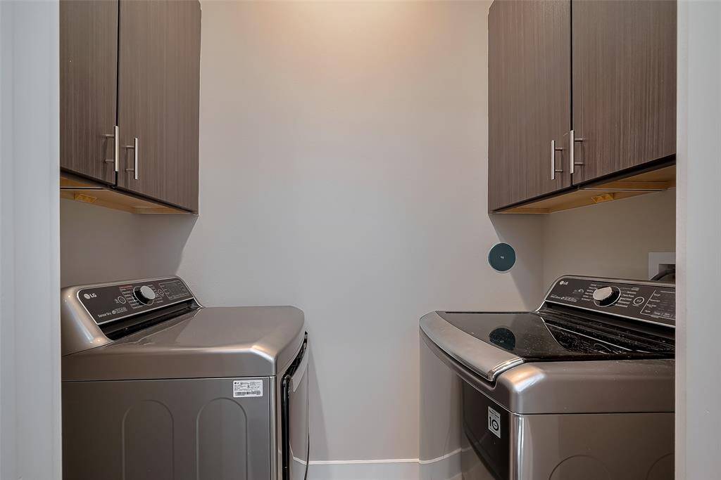 On the 2nd floor, conveniently located between the owner's suite and Bedroom #2, is the utility room featuring an LG washer and dryer. Storage cabinets above each unit offer added convenience. The room is plumbed for both gas and electric dryer connections. Thoughtfully designed, the home includes a 2nd-floor drain below the washer, ideal in case of an accidental overflow, providing extra peace of mind.