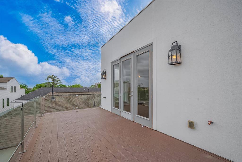 The home’s unique contemporary stairstep design leads to the upper balcony, where coach lights flank each side of the door, providing illumination at night. The durable composite decking material ensures low maintenance while adding to the sleek aesthetic. This spacious balcony offers ample possibilities for extending your living space outdoors, whether for relaxing, entertaining, or enjoying the views.
