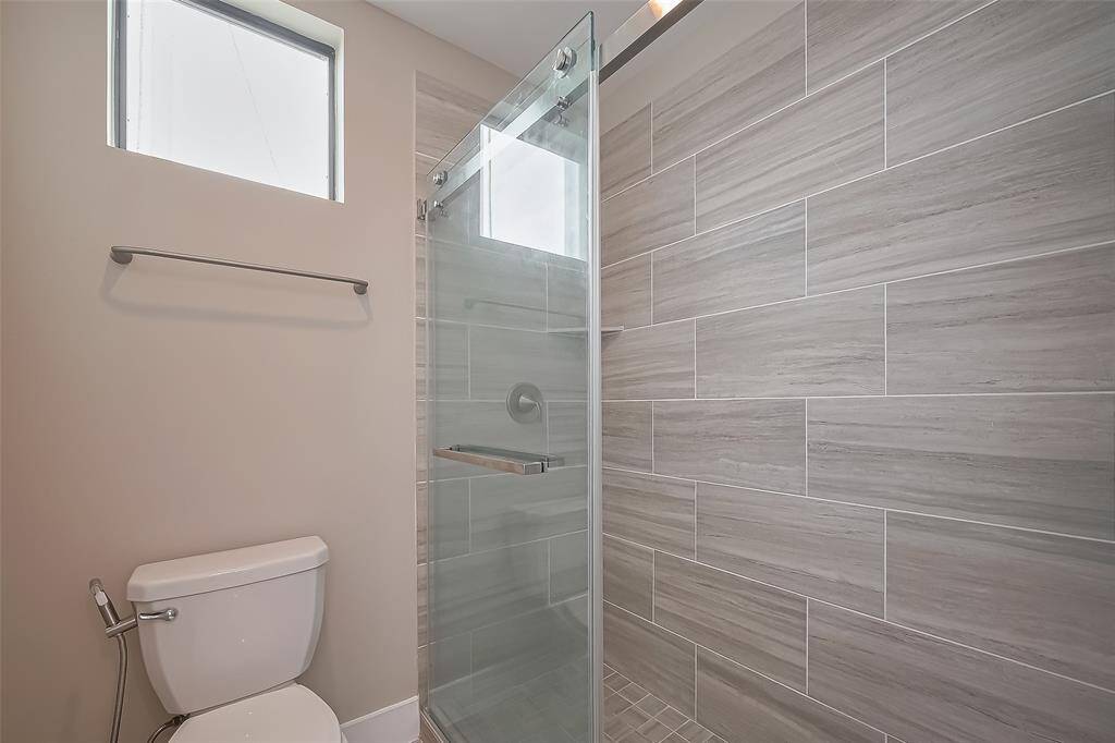 Bath #3's separate bathing area includes a walk-in shower with tiled shower walls and a tiled shower floor, giving the space a sleek and modern feel. The sliding barn-style shower door adds a stylish touch, completing this contemporary and functional bathing area.