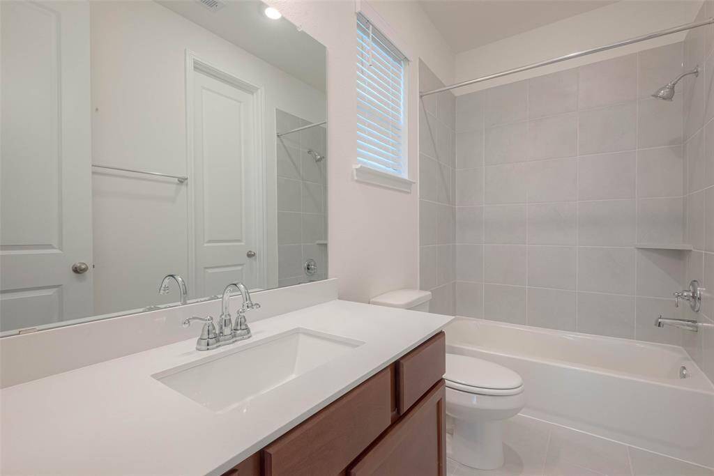Secondary bathroom with tub/shower combo, shared by two secondary bedrooms.