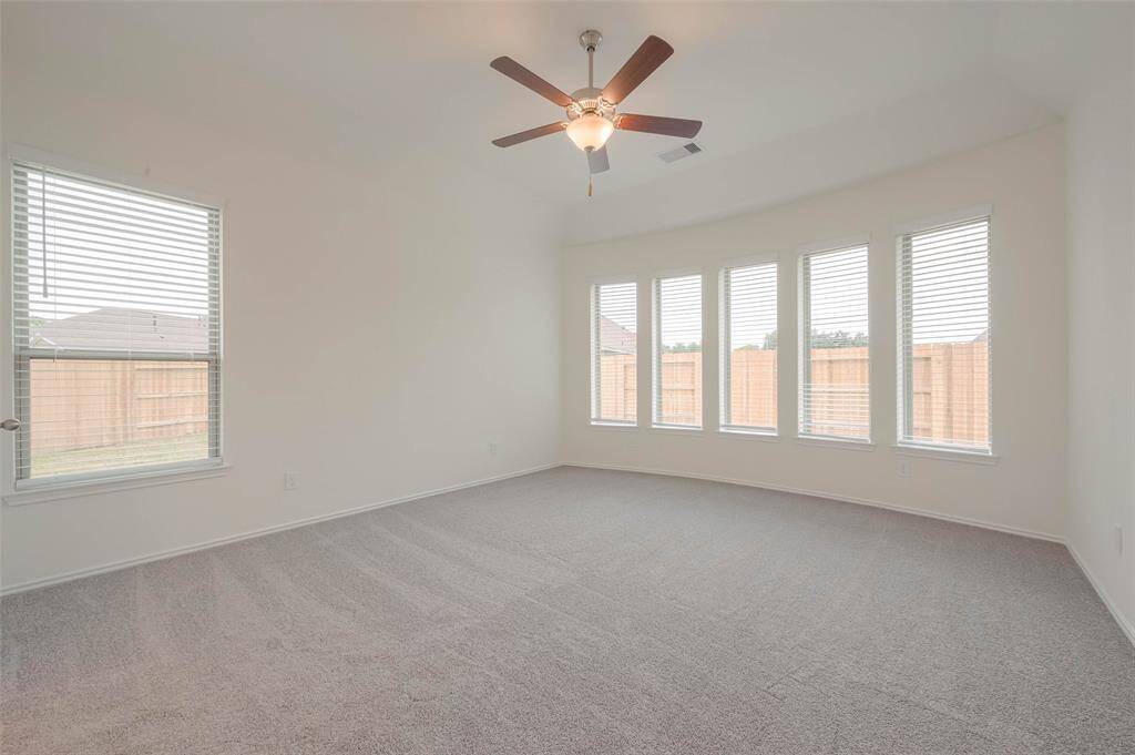 Primary bedroom flooded with natural light from the abundant windows.