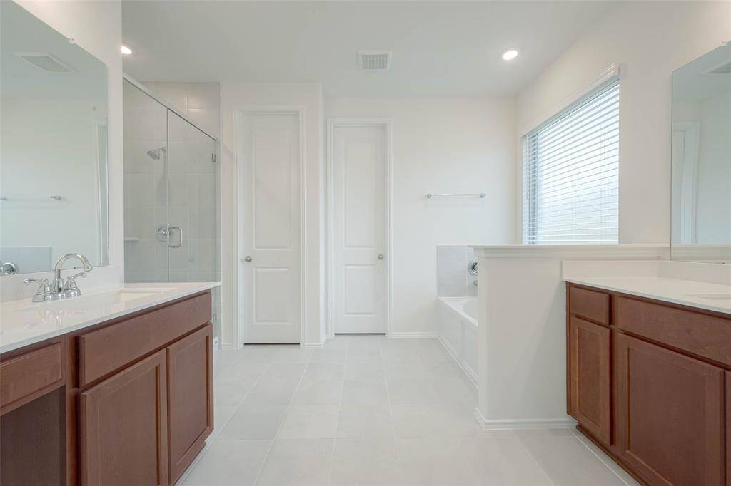 With dual vanities, soaking tub, separate shower, and an expansive walk-in closet.