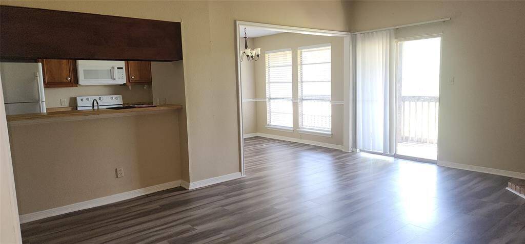 Large den with fireplace and sliding glass door lead to patio/balcony