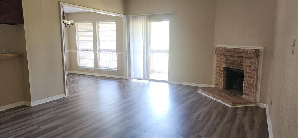 Large den with fireplace and sliding glass door lead to patio/balcony