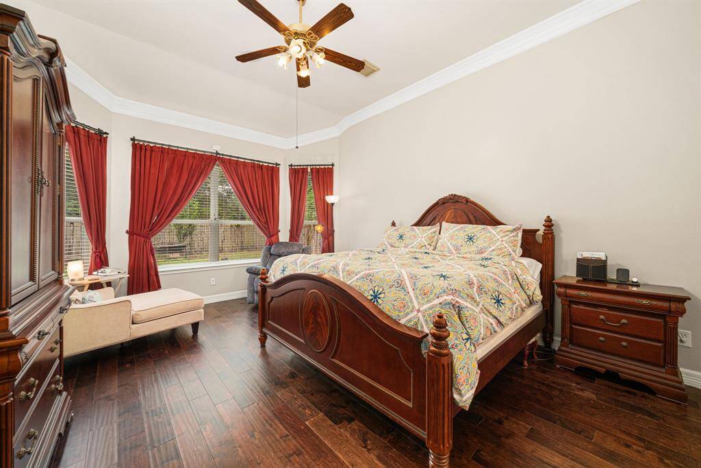 Relax comfortably in this beautiful Primary Bedroom with great windows, wood flooring, high ceiling, crown molding and ceiling fan!
