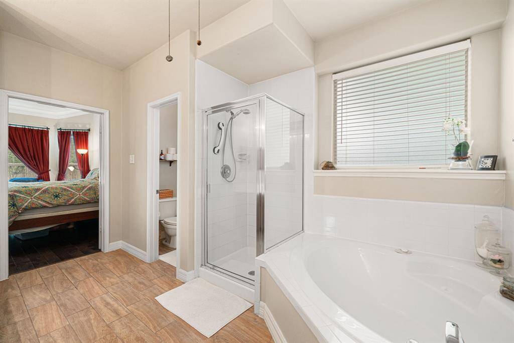 Stainless steel framed shower with tile surround, and stainless steel fixtures throughout Master Bathroom.