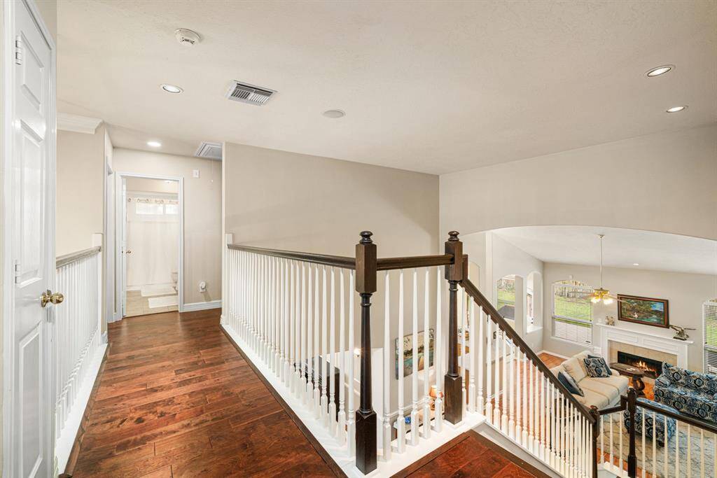 Upstairs hallway overlooks the eye-catching staircase to the entry and family room downstairs