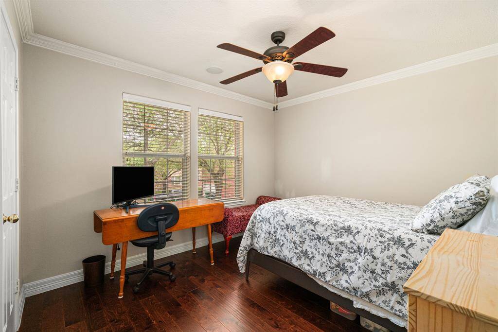 Bedroom 3 with wood floors continuing, ceiling fan and ample closet space.