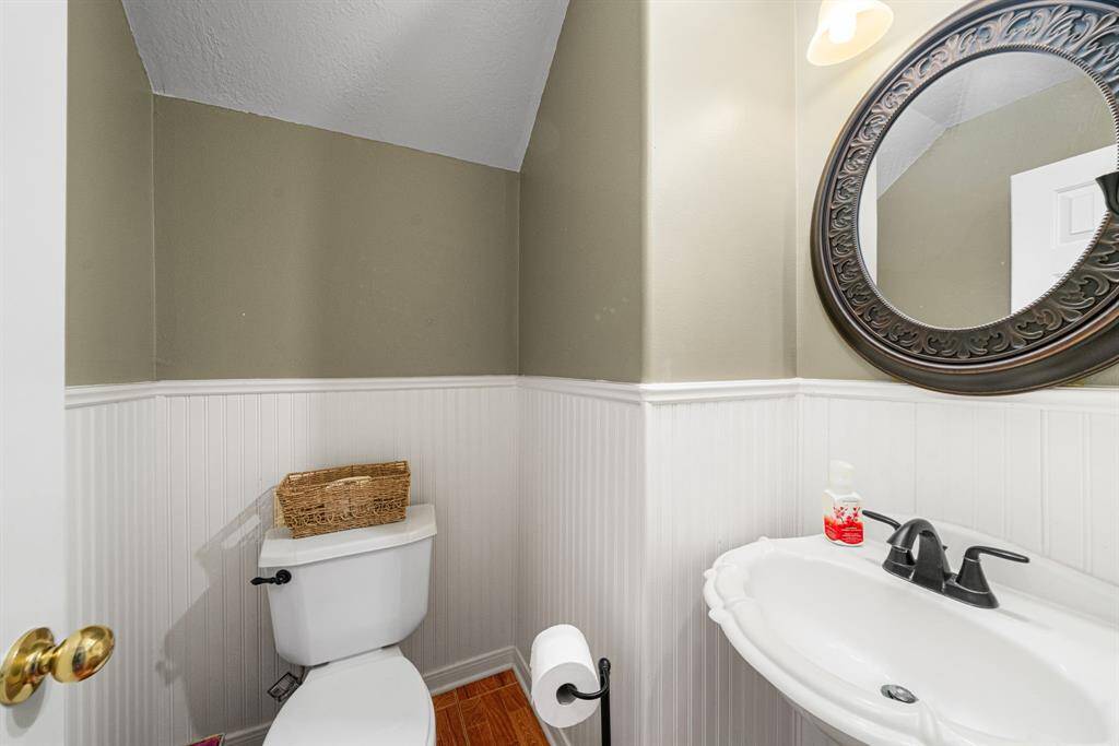 Guest bath downstairs with charming bead board wall, pedestal sink and decorative mirror