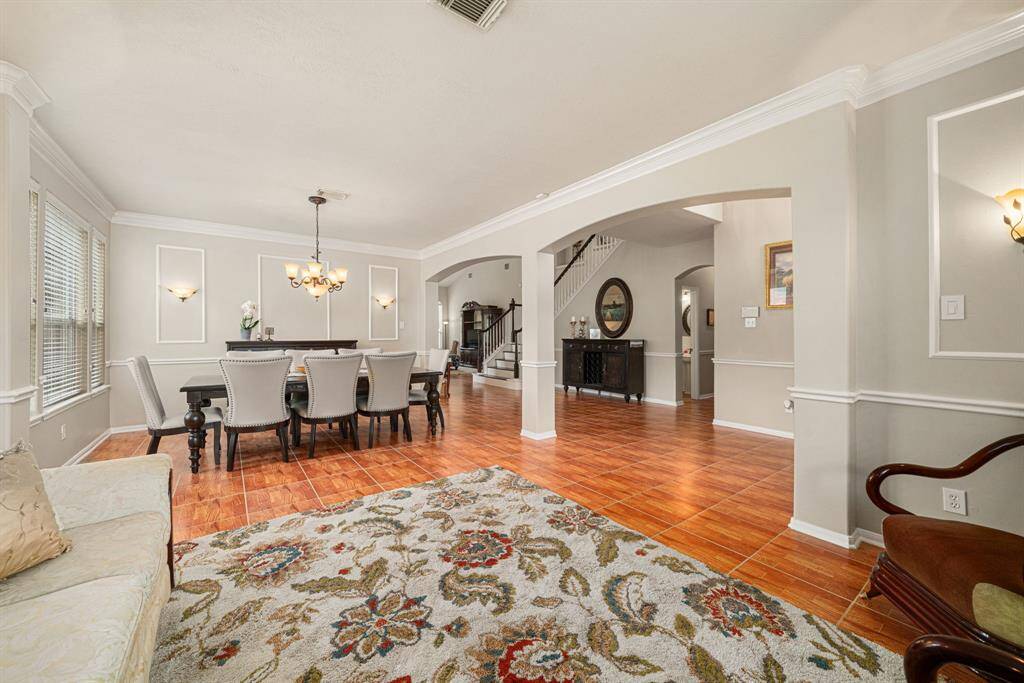 Formal living and formal dining room accentuated with picture frame molding, crown molding, and arched walkways