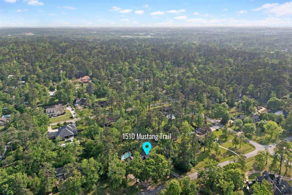 Aerial view of wooded residential area.  The neighborhood is characterized by spacious lots, mature trees.