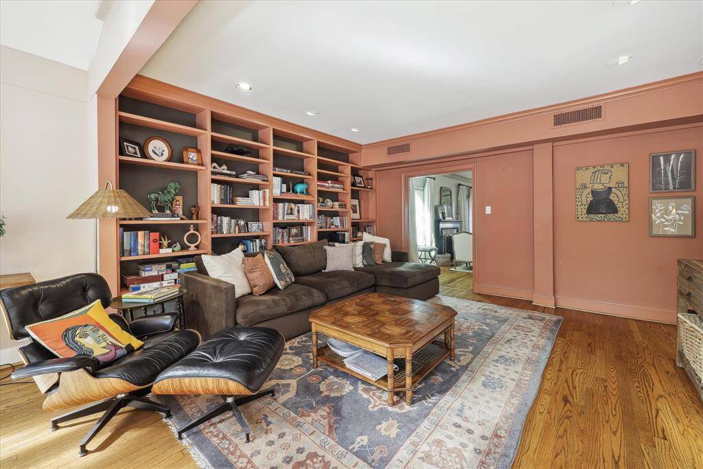 Cozy family room with hardwood floors, recessed lighting, and built-in library shelving.