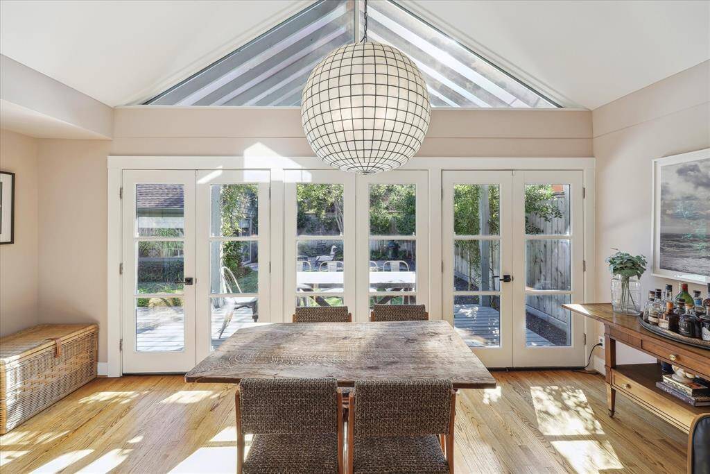 Inviting light-filled sun room with doors that lead to covered patio/deck and backyard.