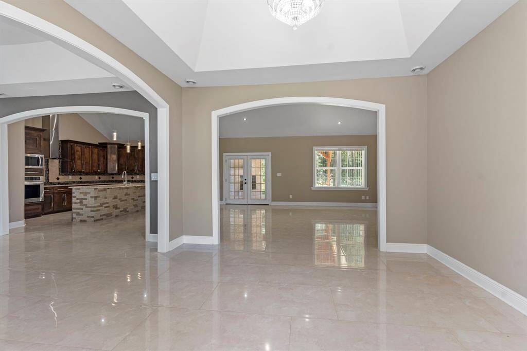 Formal foyer at the entry with the formal dining to the right and open concept kitchen and living space ahead.