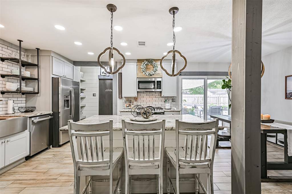 Striking 6 ft shiplap island anchors the kitchen with granite countertops and farmhouse pendant lighting—combining style, function, and plenty of space to gather.