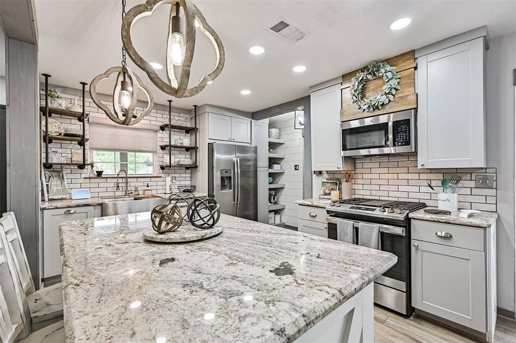 The 6 ft kitchen island features a stunning 2 CM White Paradise granite countertop, offering a sleek, durable surface with a sophisticated, light-colored finish that complements the modern design.