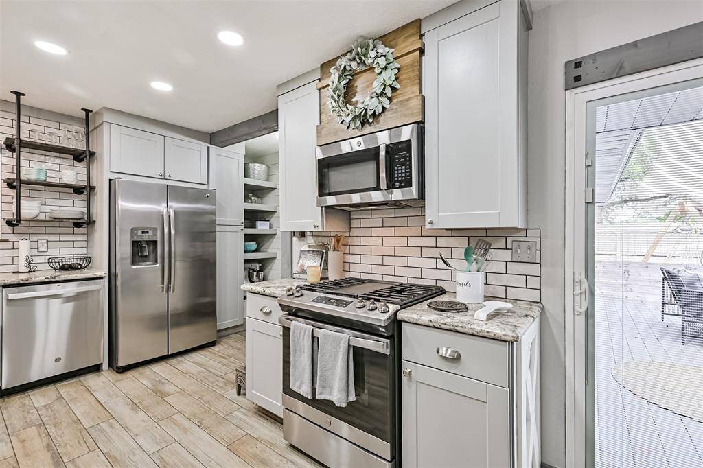 The kitchen is equipped with a high-end 30" GE 5-burner gas range and a Dry Boost top control dishwasher (Energy Star certified)—perfect for efficient cooking and cleaning with modern, energy-saving features.