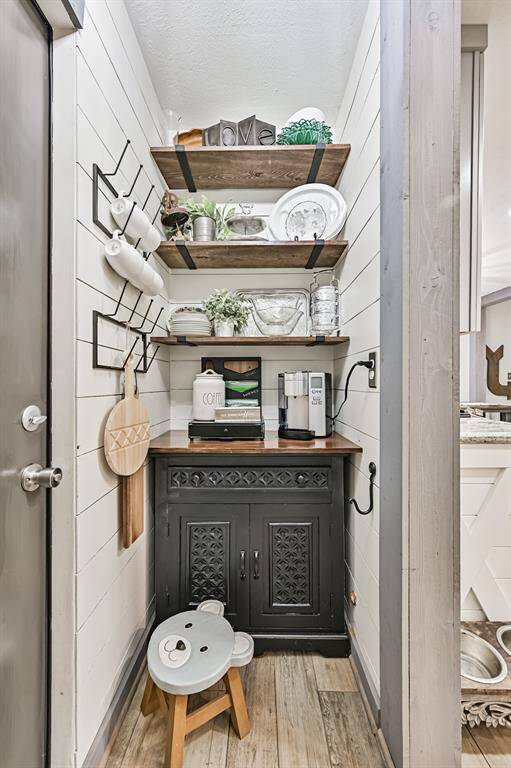 A custom wood hutch coffee bar with open floating industrial shelves adds charm and functionality—perfect for your morning coffee routine or displaying your favorite mugs and decor in style.