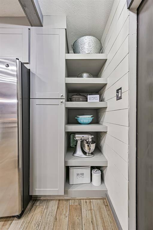 The pantry boasts open shelving for easy access to larger items, complemented by spacious cabinets for organized storage—ensuring everything has a place in this thoughtfully designed space.