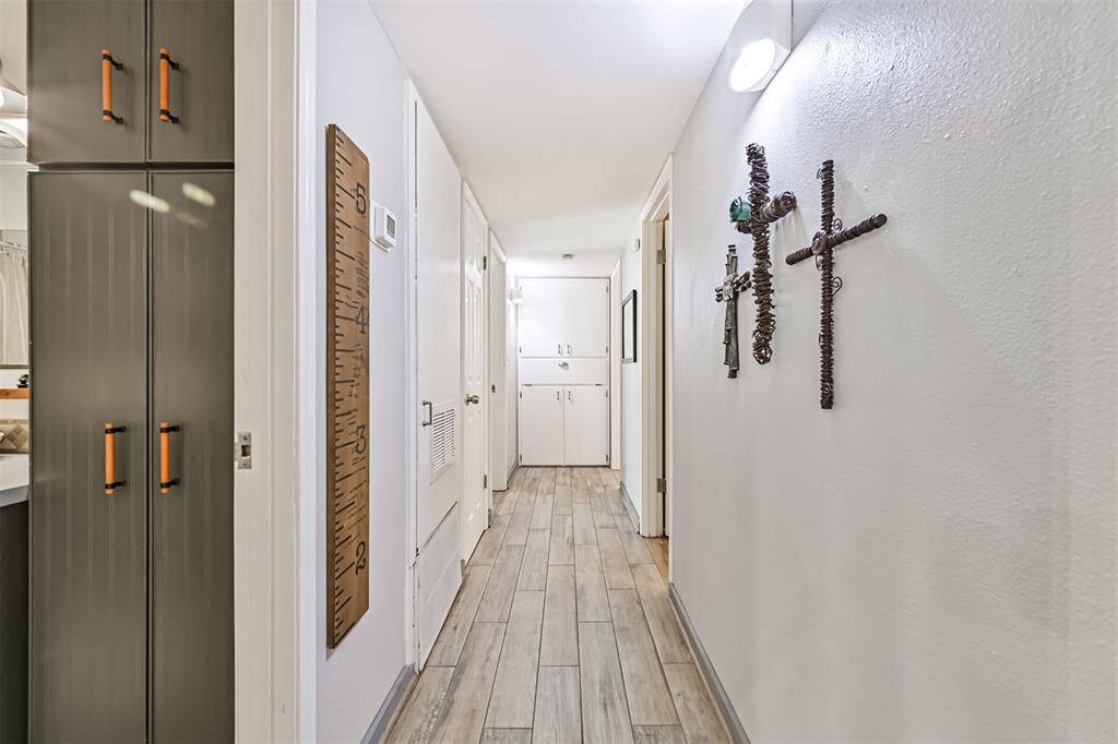 The hallway leading to the bedrooms offers a seamless transition, with newly installed tile flooring and thoughtful design, ensuring both function and flow throughout the home.