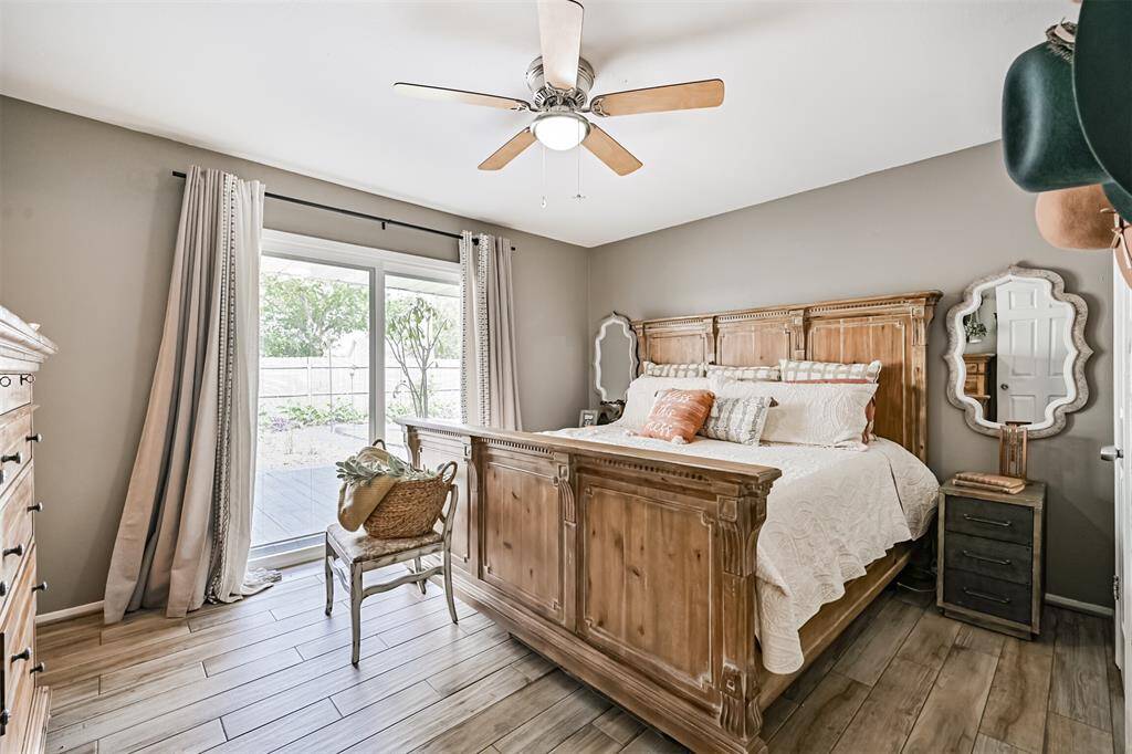 The primary bedroom offers a serene retreat with a spacious closet featuring custom shelving for optimal organization. A sliding glass door opens directly to the backyard oasis, blending indoor and outdoor living for the ultimate relaxation experience.