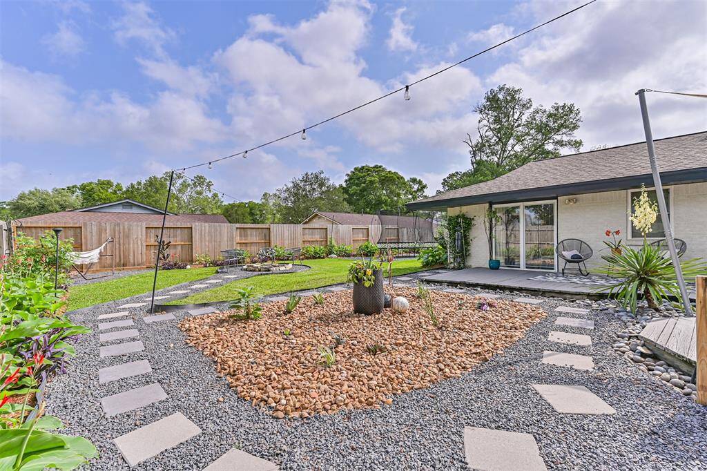 String lights are elegantly draped throughout the backyard, casting a warm, inviting glow that transforms the outdoor space into a cozy retreat perfect for evening gatherings or quiet nights under the stars.