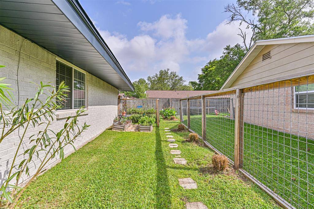 The dog run area is thoughtfully designed with raised garden beds, offering both a secure space for pets and a spot for growing your favorite plants, making it a functional and stylish addition to the backyard.