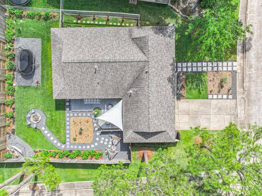 This comprehensive view of the home, capturing both the front and backyard with impeccable landscaping. From the lush greenery and river rock accents to the carefully designed stepping stone paths and private outdoor spaces, this shot beautifully highlights the home’s distinctive layout and stunning curb appeal.