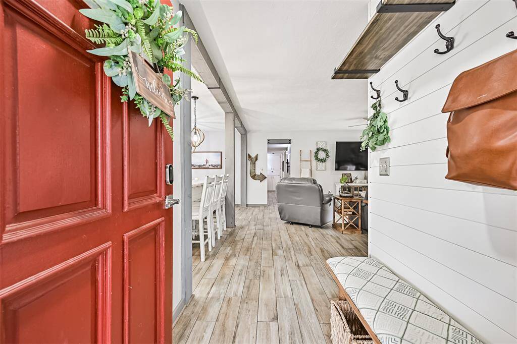 Reimagined entryway sets the tone with fresh tile flooring, a custom hall tree, and open sightlines—creating a warm, functional welcome as soon as you step inside.