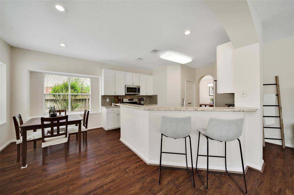 A breakfast bar keeps the kitchen open to the family room and casual dining area.