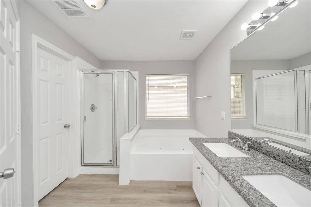 The primary bathroom features a beautiful walk-in shower and a separate tub combo, offering the perfect space to relax and unwind!