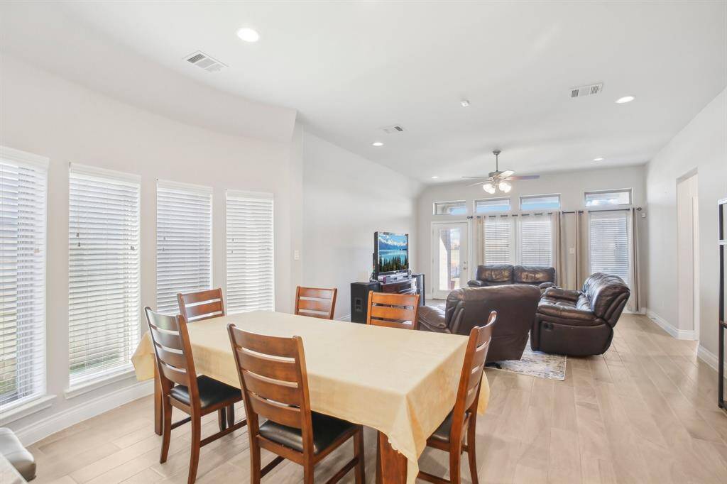 Dining Area with Curved Wall of Windows, Dining area, featuring a striking curved wall of windows, effortlessly flows into the welcoming family room, creating a seamless open-concept living space.