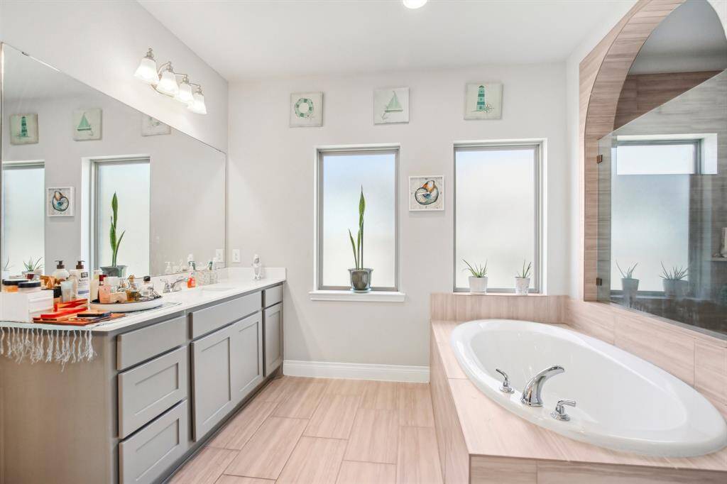 Spa-Like Primary Bath: Double sinks, expansive countertops, and upgraded cabinet hardware create a luxurious feel, while the oversized shower and vanity dressing mirrors elevate the space, transforming the primary bath into a private retreat.