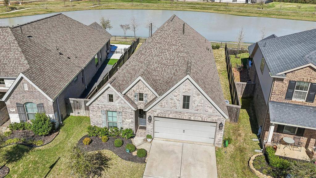 Stunning Aerial View, showcasing the captivating front elevation and the serene back lake view, this aerial perspective highlights the beauty and unique features of your potential New Home.